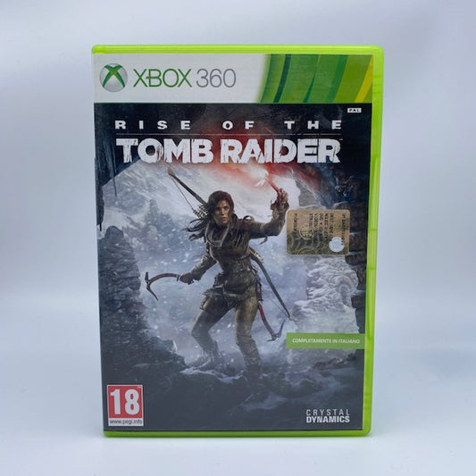 Rise Of The Tomb Raider X360 Xbox 360 Square Enix Pal Ita, lara croft all'imbocco di una caverna con torcia e piccozza, montagna innevata dietro